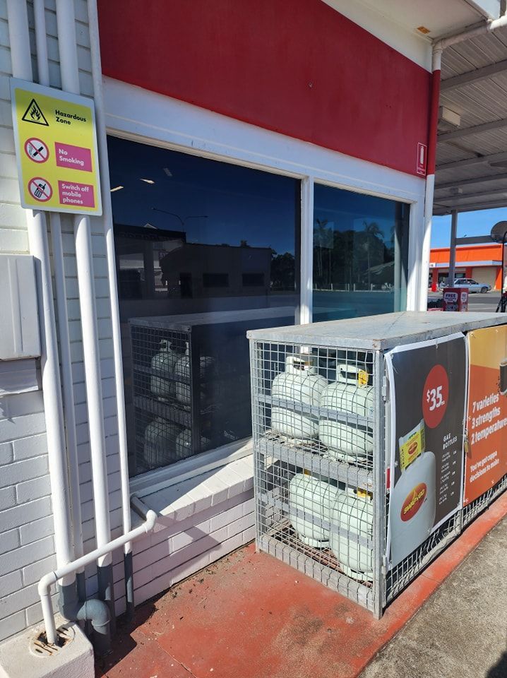 A cage filled with gas cylinders is outside of a gas station — Ace Tinting in Mareeba, QLD
