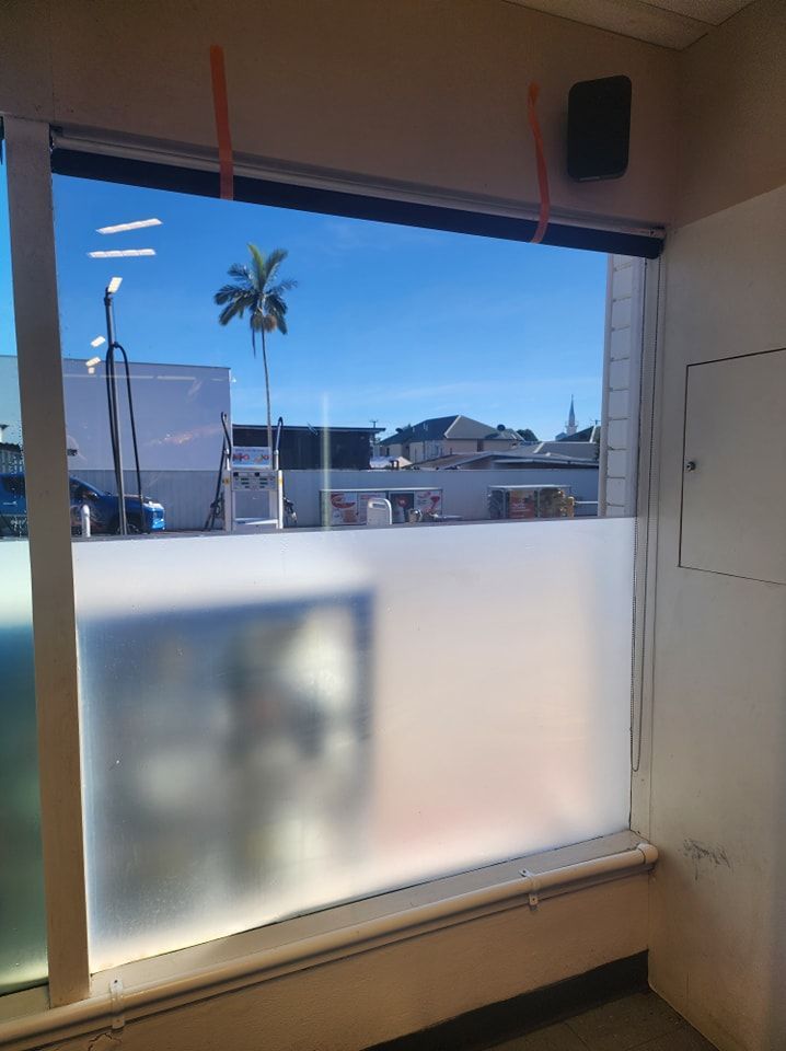 A window with a sliding glass door and a palm tree in the background — Ace Tinting in Mareeba, QLD
