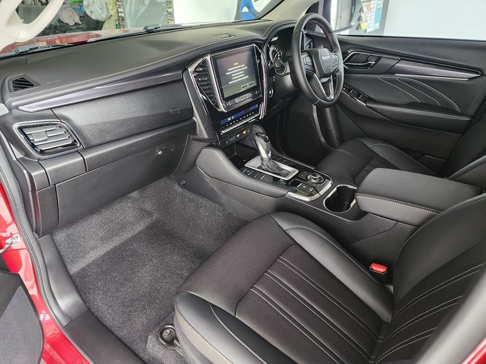 The interior of a red car with black seats and a steering wheel — Ace Tinting in Mareeba, QLD