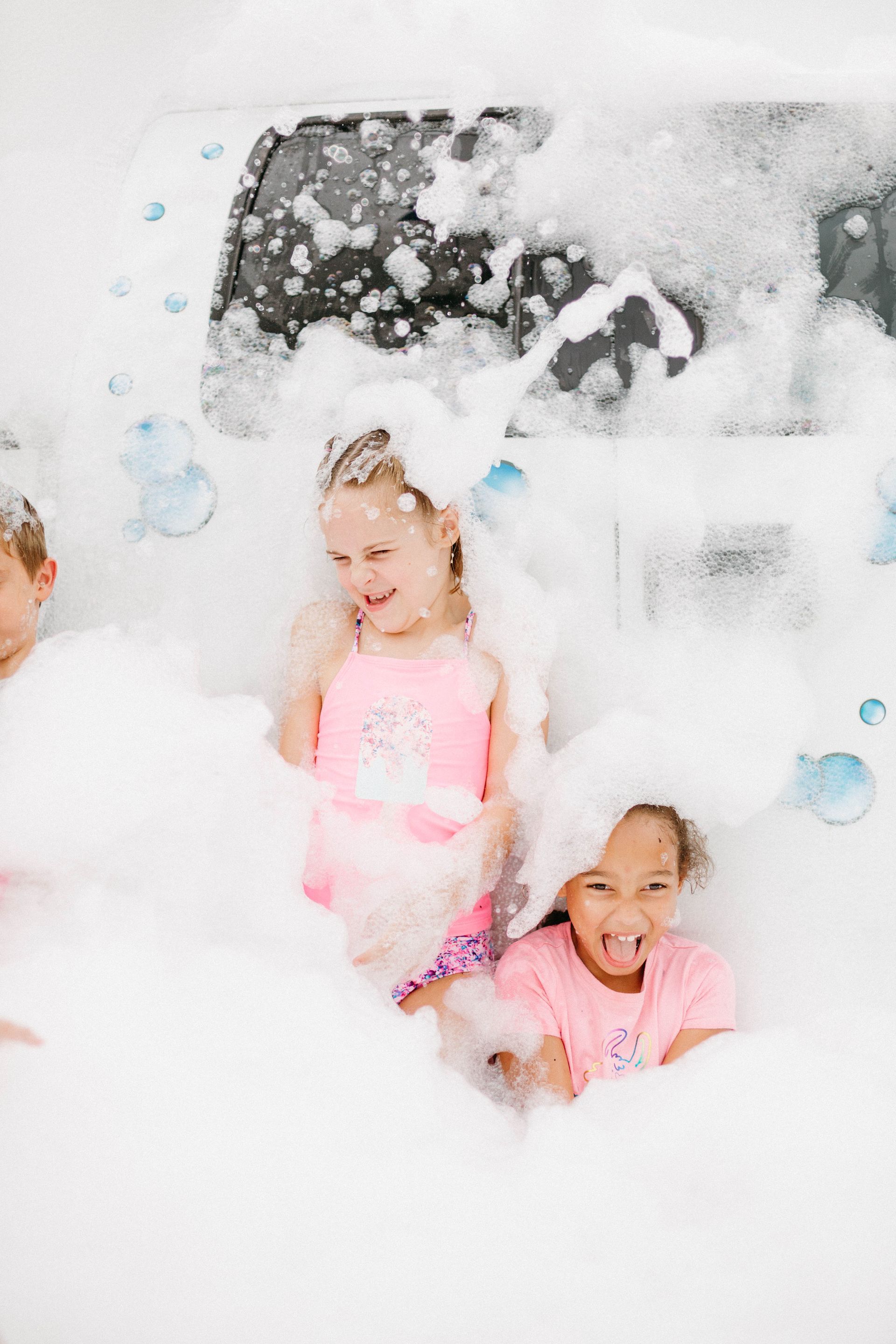 Kids playing in foam from a bubble truck