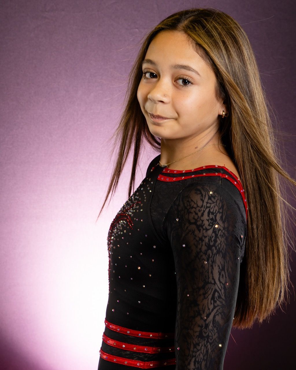 Portrait of a person in a black dress with red trim against a purple background