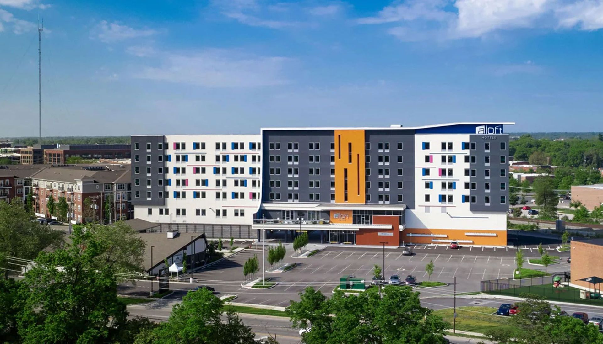 An aerial view of a large building with a parking lot in front of it.