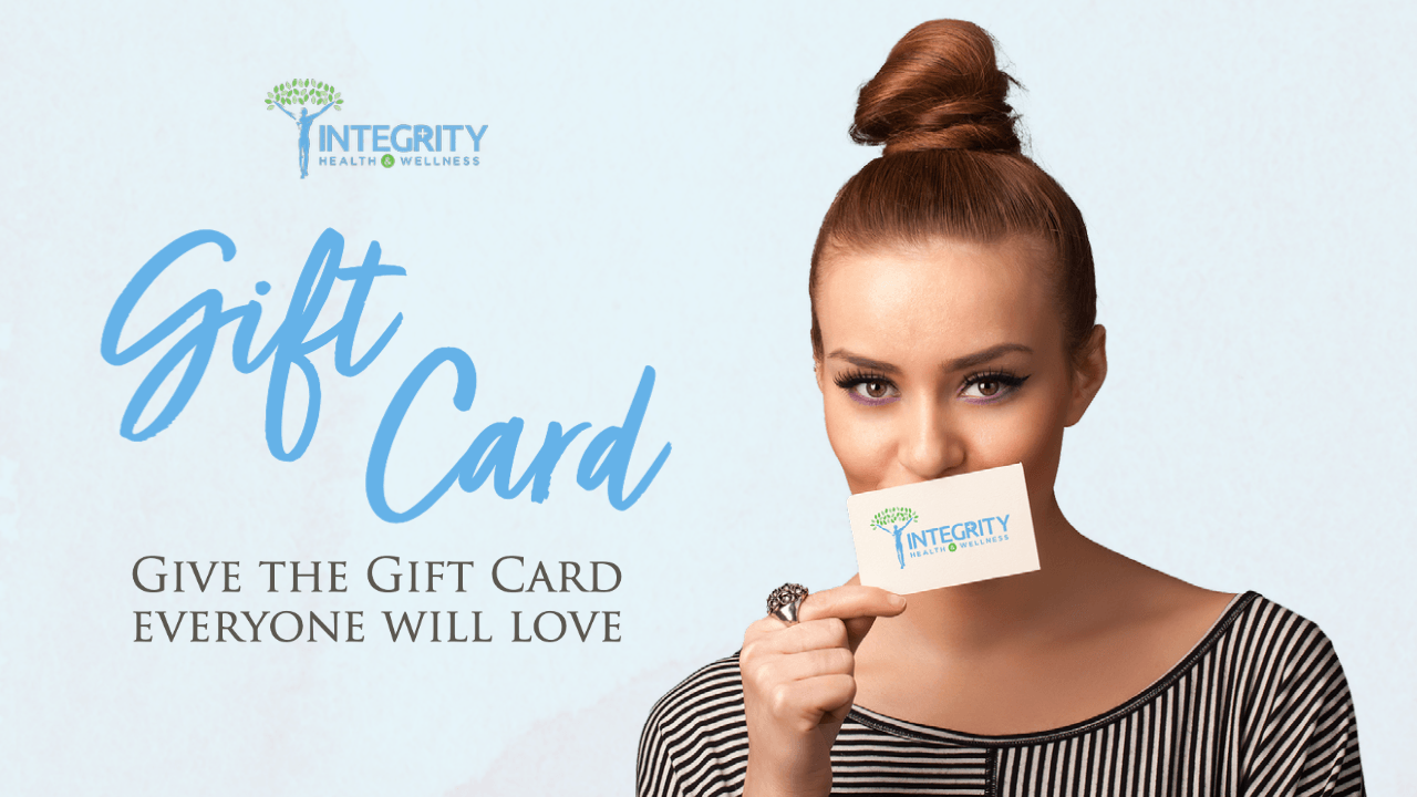 A woman is holding a gift card in front of her mouth.