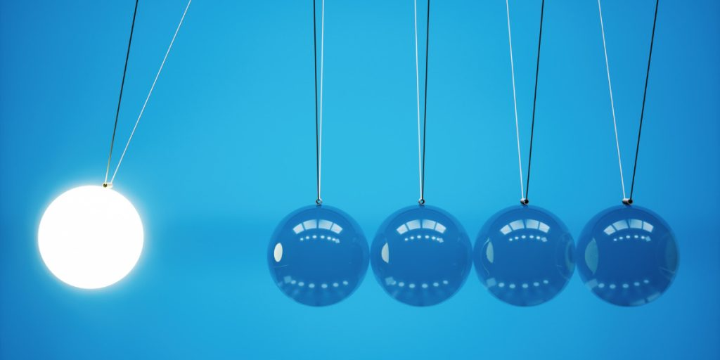 A newton 's cradle with balls hanging from a string on a blue background.