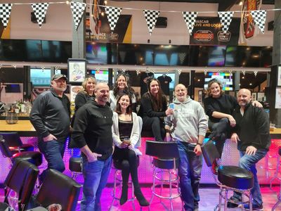 A group of people are posing for a picture in a bar.