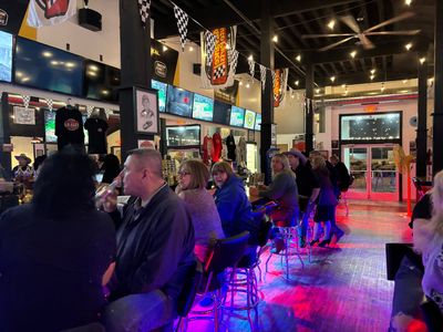 A group of people are sitting at tables in a restaurant.