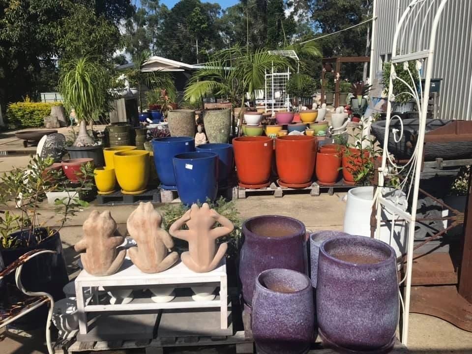 A Bunch Of Pots Are Sitting On A Table In A Garden — Cooroy Landscape Supplies And Garden Centre In Noosa, QLD