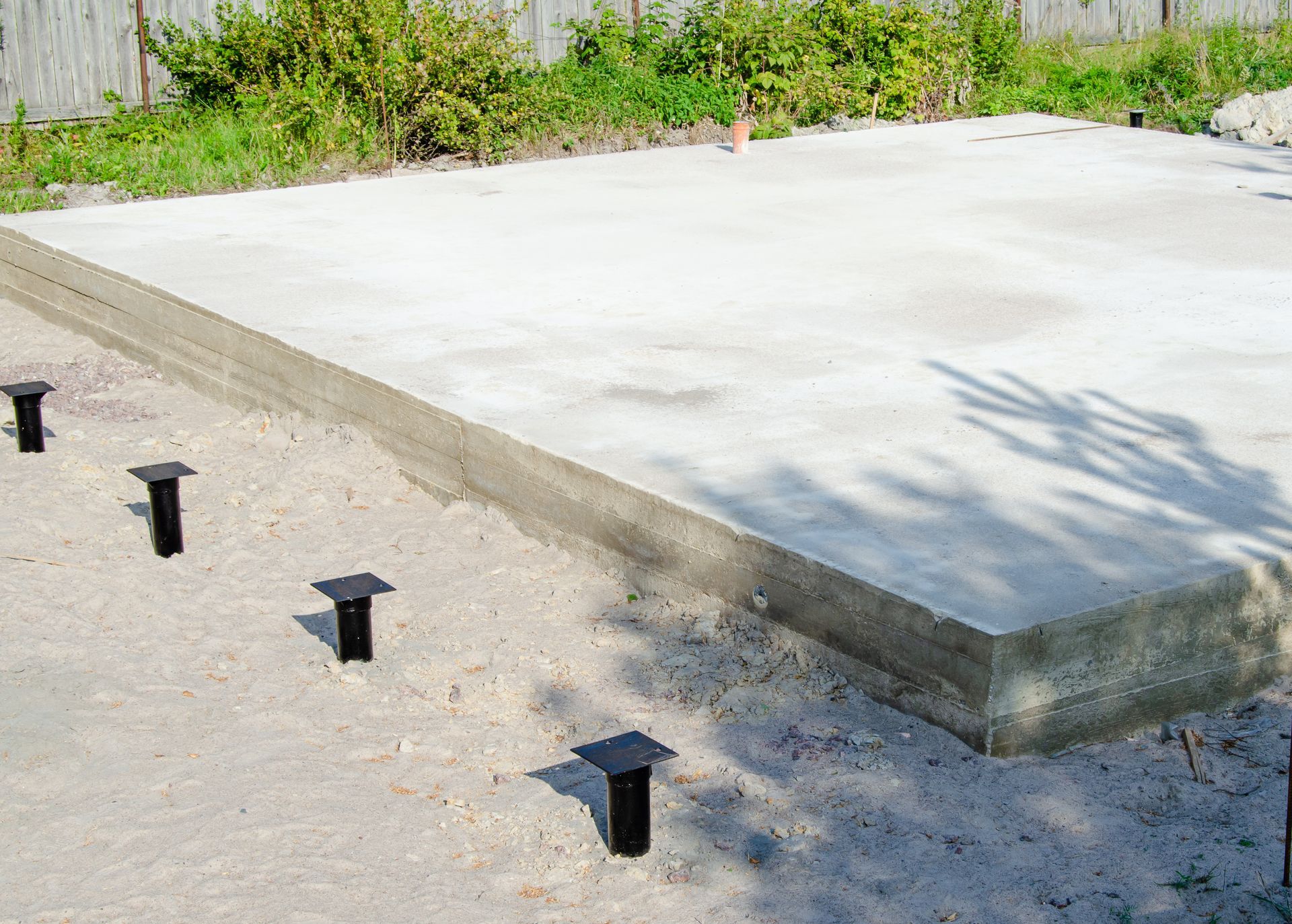 Concrete Slab Foundation With Several Black Bolts Protruding — Ground Screws SEQ Pty Ltd In Meridan Plains, QLD