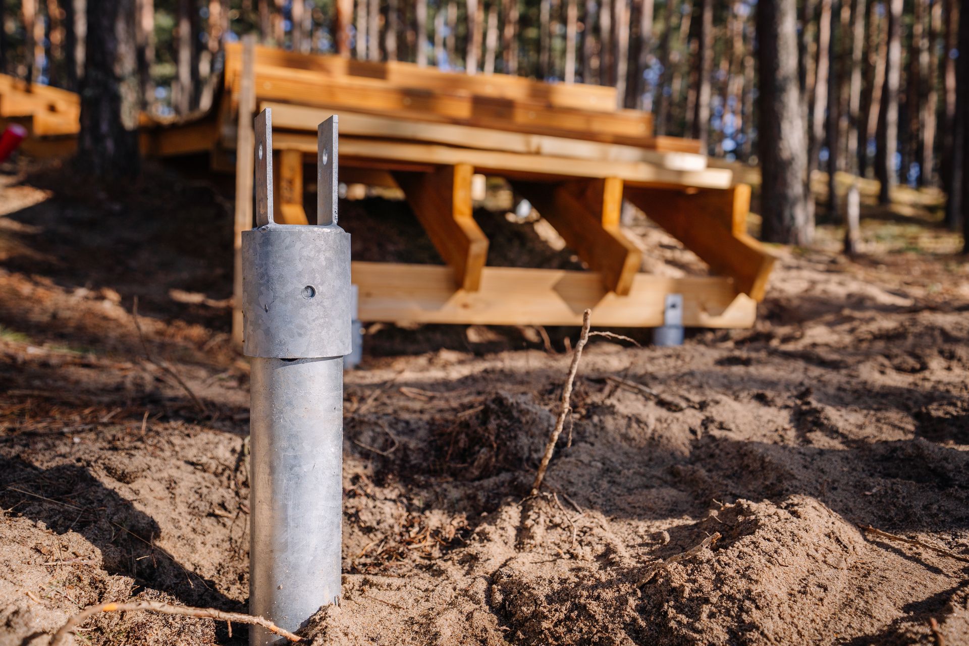 A Metal Post in the Dirt Foreground With a Picnic Table on a Wooded Site — Ground Screws SEQ Pty Ltd In Meridan Plains, QLD