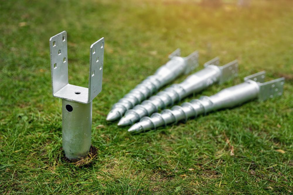 Metal Ground Anchor With Mounting Bracket on Grass, With Several Screw-in Stakes— Ground Screws SEQ Pty Ltd In Gympie, QLD