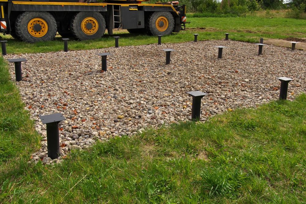 Gravel Foundation With Black Support Posts in a Grassy Area — Ground Screws SEQ Pty Ltd In Meridan Plains, QLD