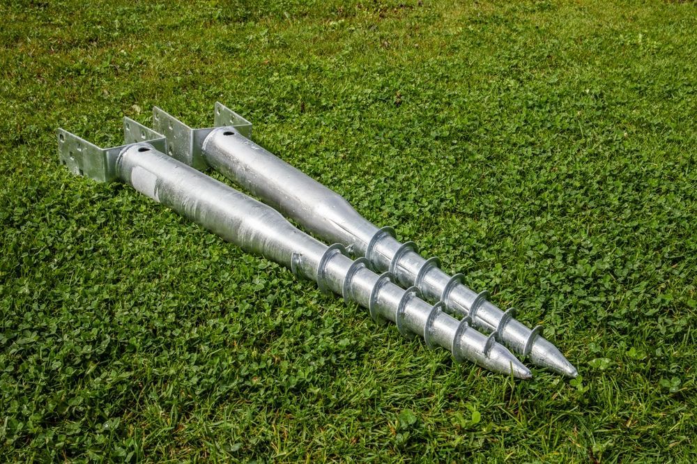 Two Silver Metal Augers or Drill Bits Lying on Grass — Ground Screws SEQ Pty Ltd In Meridan Plains, QLD