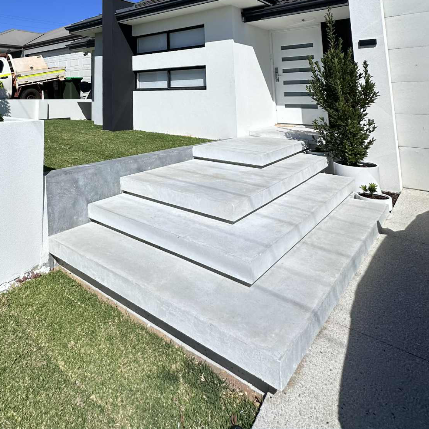 Grey floating staircase at front entrance of Perth home. 