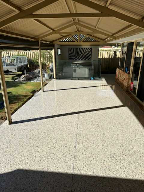 Honed concrete patio flooring in Perth backyard with spa and pool fence
