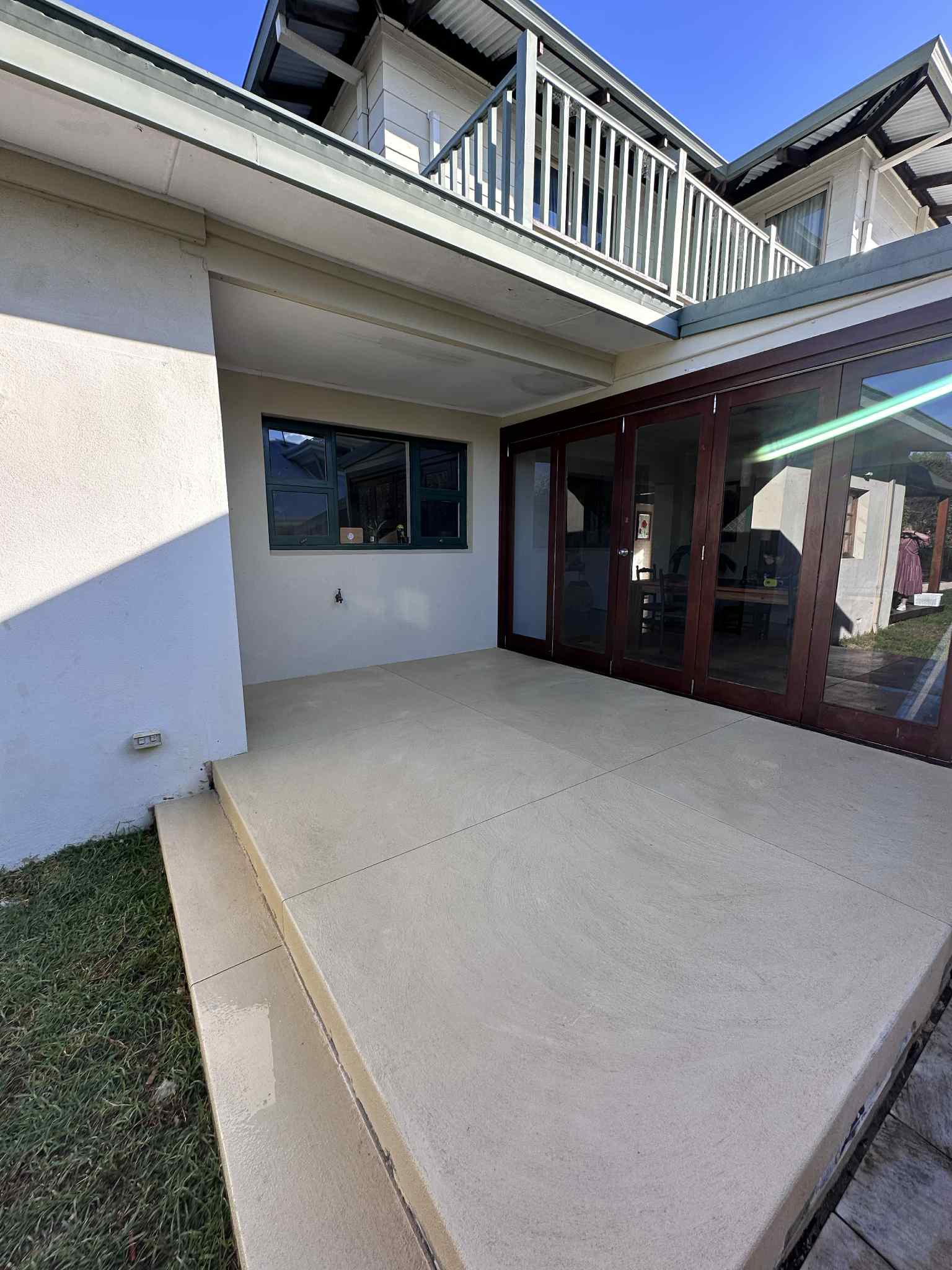 Liquid limestone outdoor seating area with stairs leading into back garden.