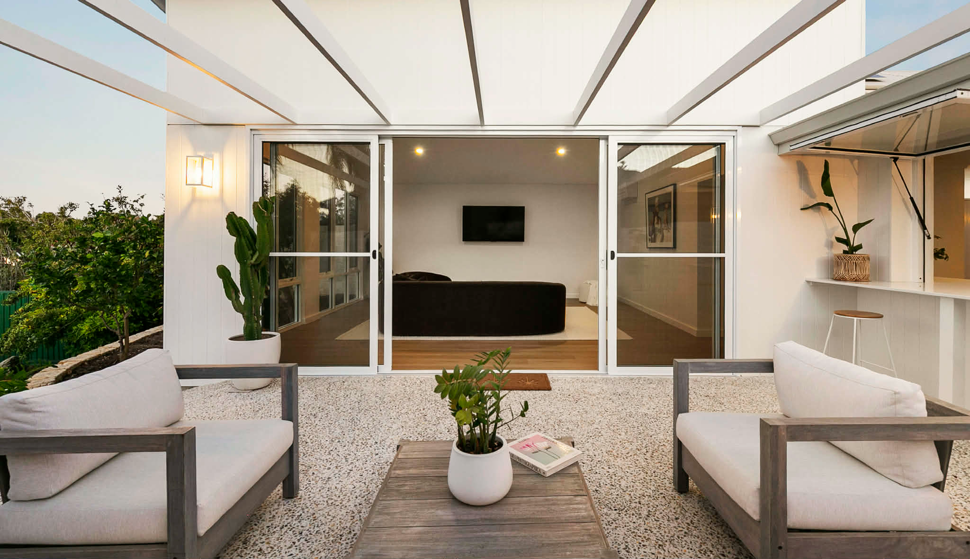 Modern open air patio with white exposed aggregate concrete flooring.