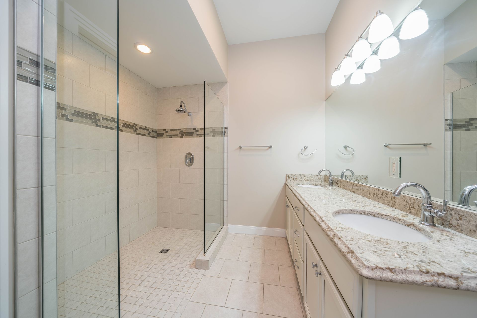 A bathroom with a walk in shower , sink , and mirror.