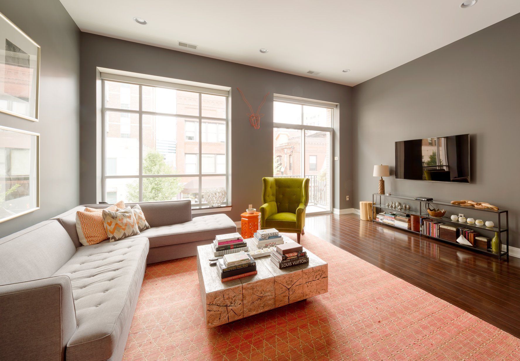 A living room with a couch , chair , coffee table and television.