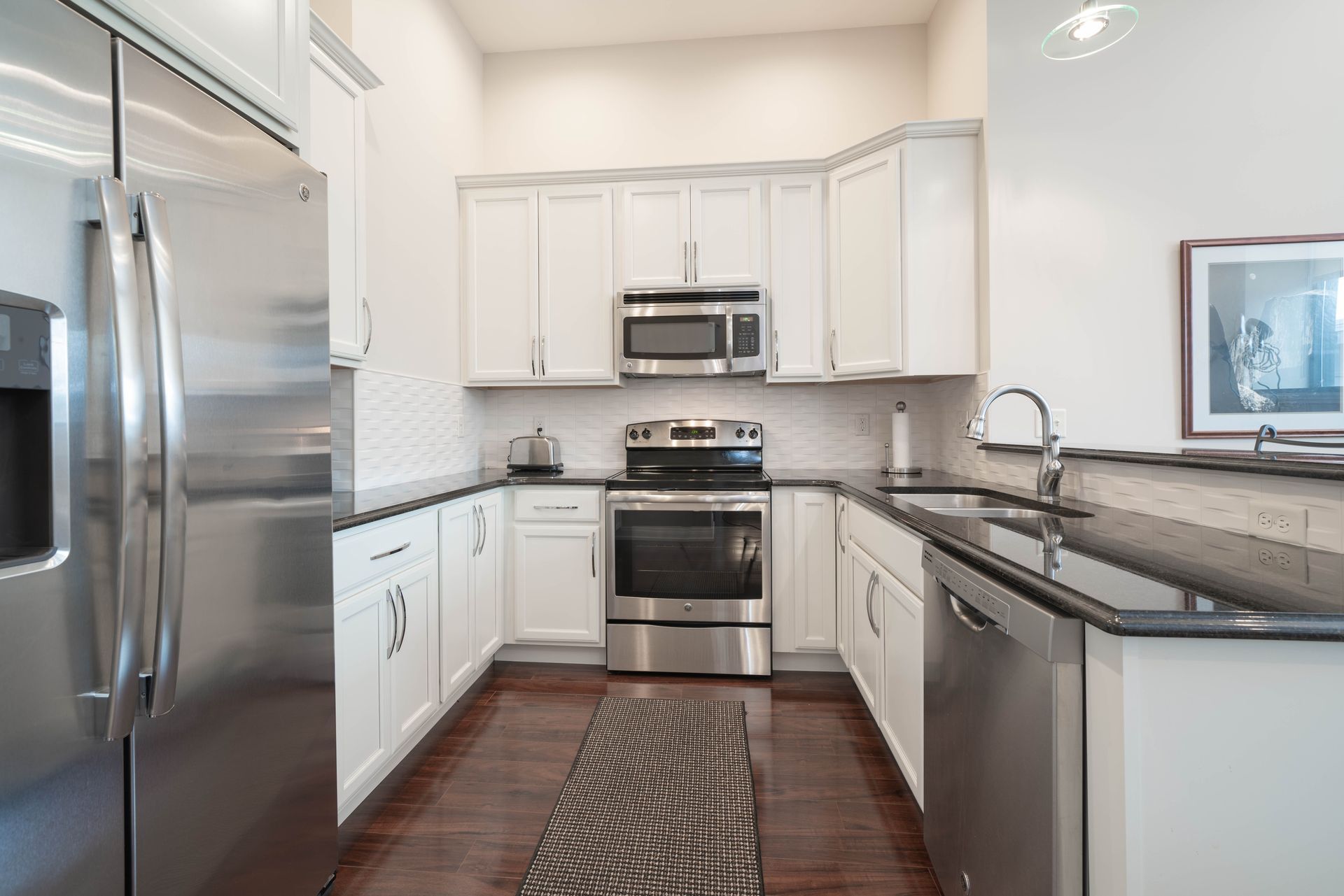 A kitchen with stainless steel appliances and white cabinets