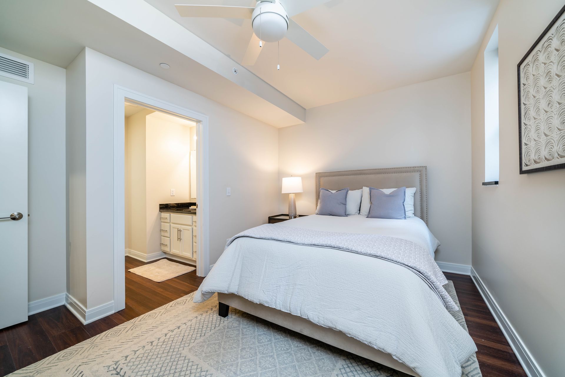 A bedroom with a king size bed and a ceiling fan.