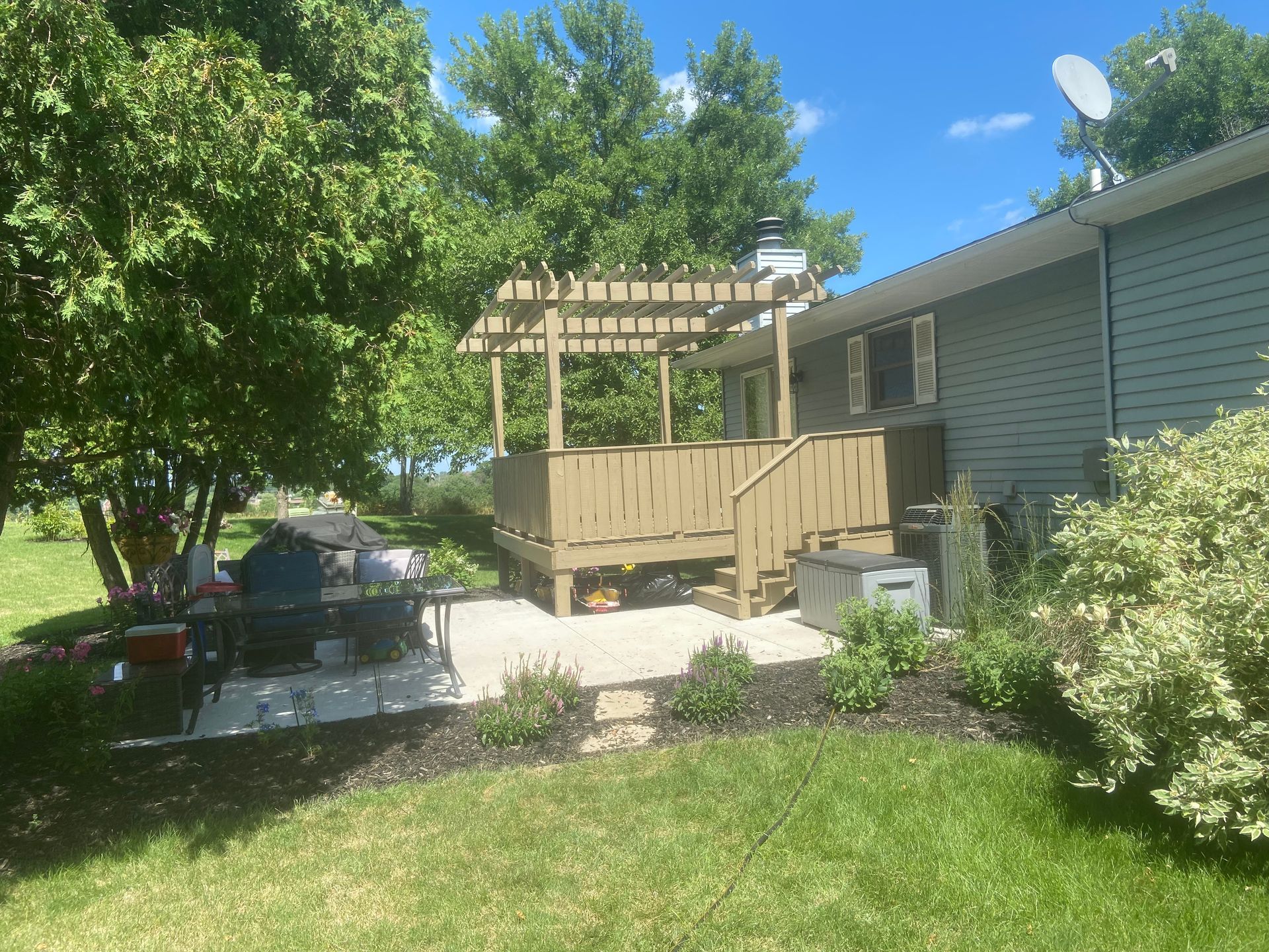 A house with a deck and a pergola in the backyard.