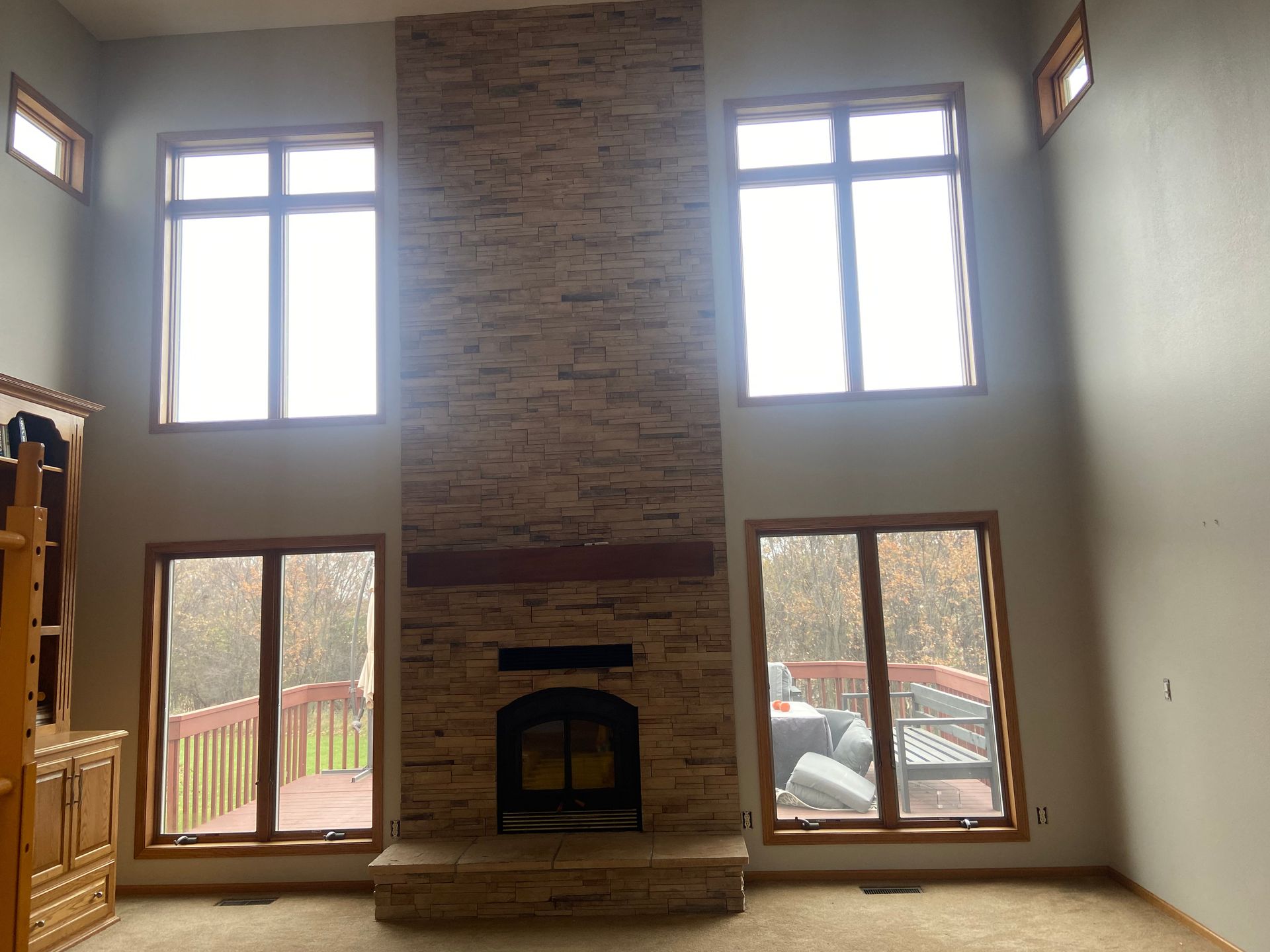 A living room with a fireplace and lots of windows