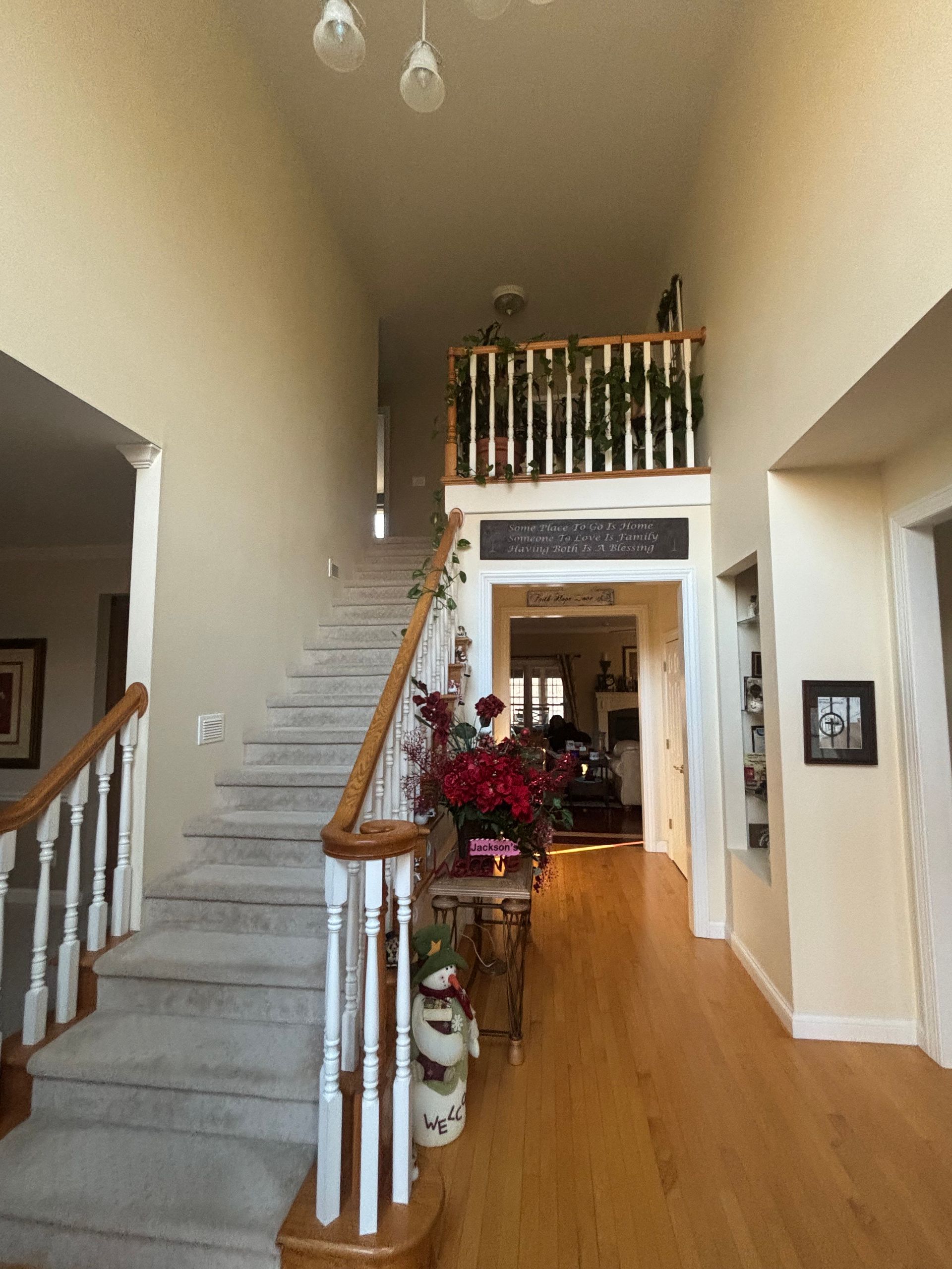 A living room with a fireplace and a lot of windows is being painted.