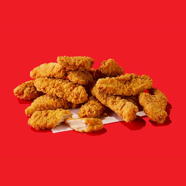 A pile of fried chicken strips on a red background.