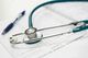 Stethoscope on medical forms with a pen; healthcare setting.