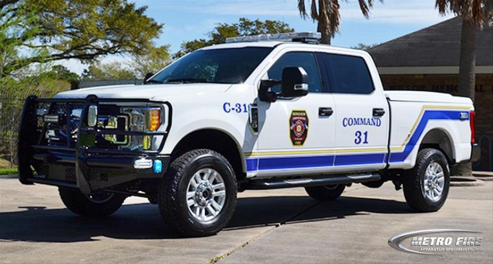 A white and blue Bergheim VFD command pickup truck is parked in front of a fire station.