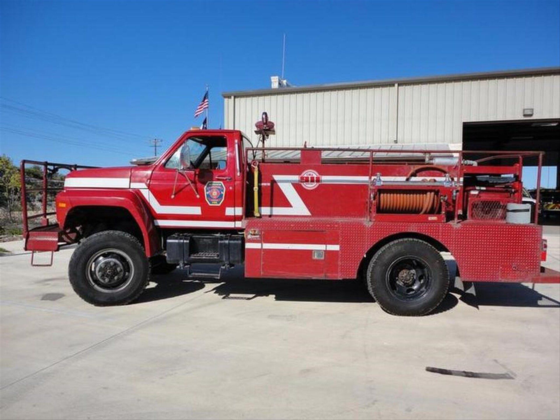 A red fire truck is parked in front of a fire station.