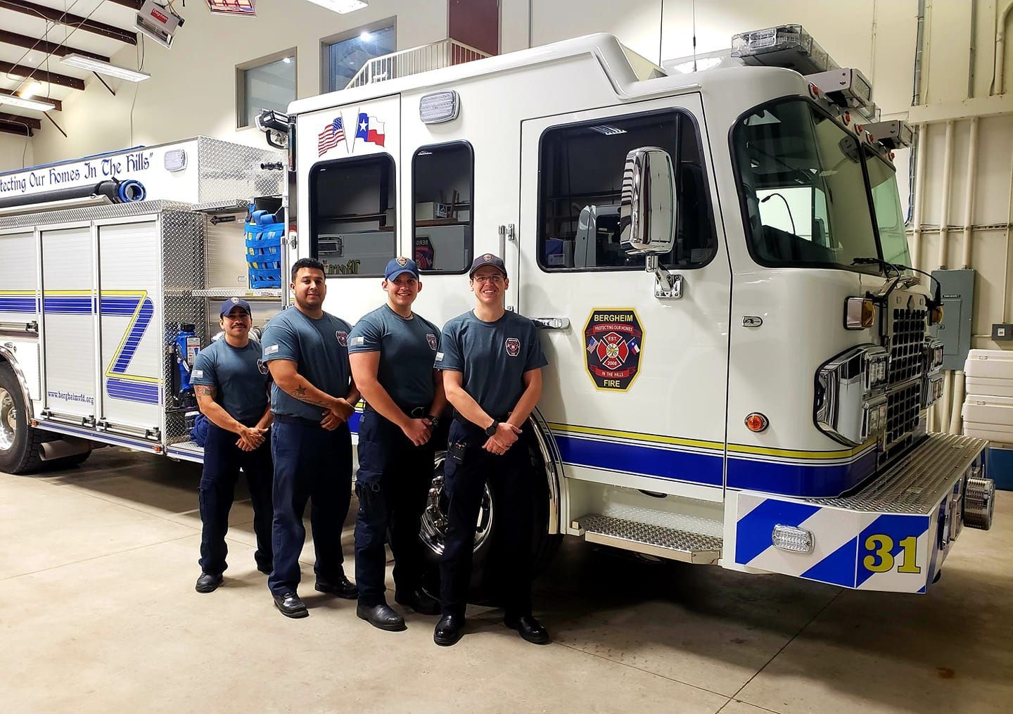 A group of firefighters are posing for a picture in front of a fire truck.