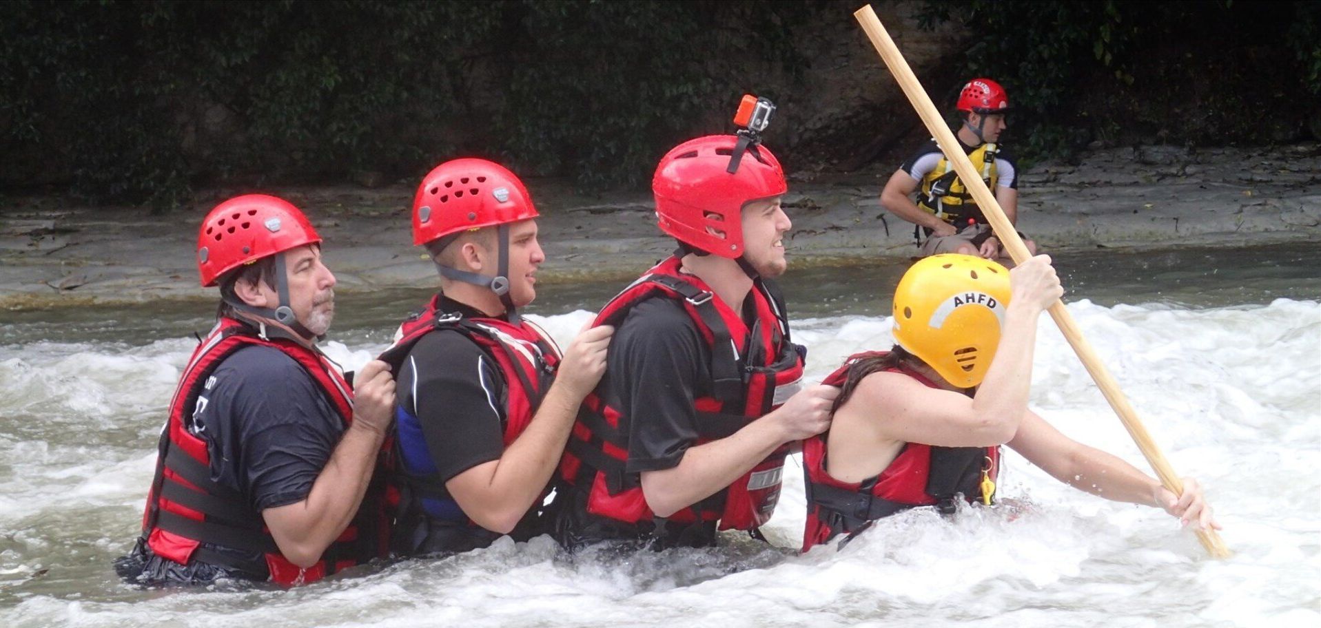 A group of fire fighters are conducting swift water training in a river