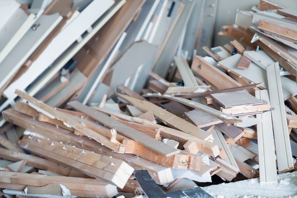 Piled wooden boards and construction debris scattered in a partially demolished room