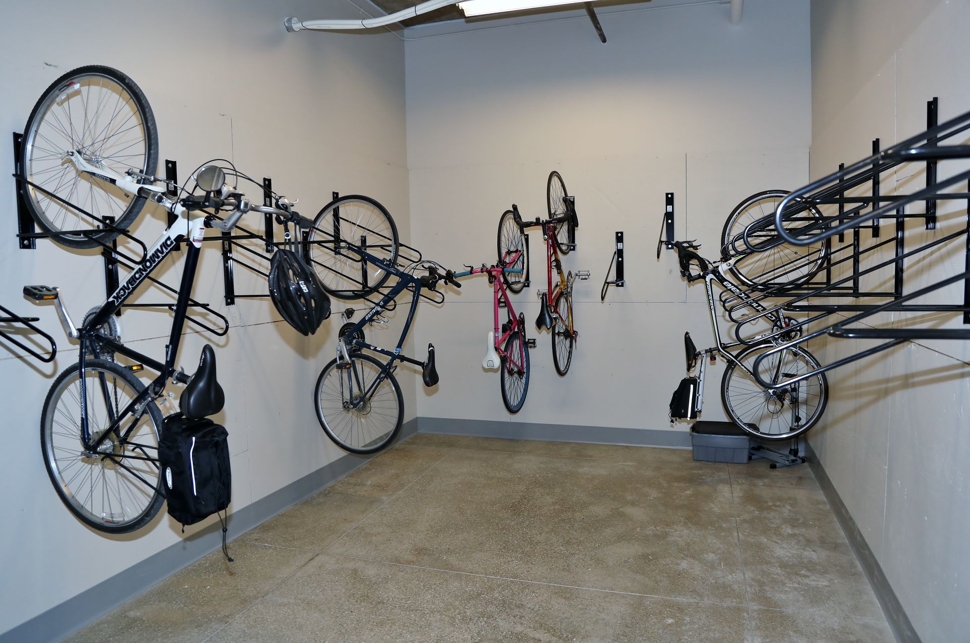 Bikes mounted on wall racks in a neutral-colored storage room.