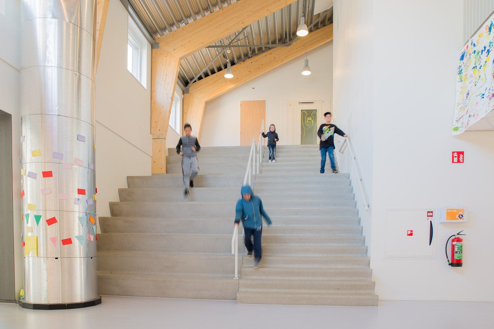 A group of children are walking up a set of stairs in a school.