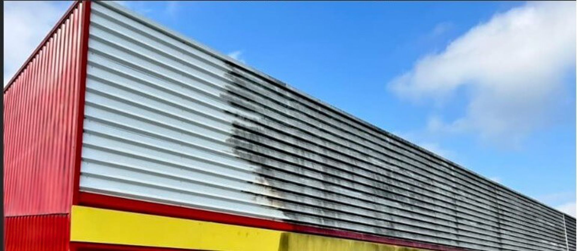 Un bâtiment rouge et jaune avec un ciel bleu en arrière-plan.