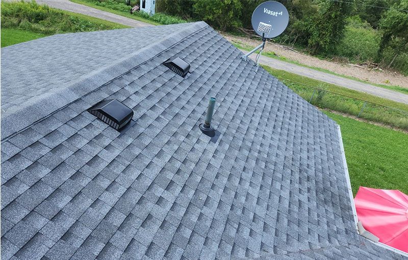The roof of a house with a satellite dish on it.