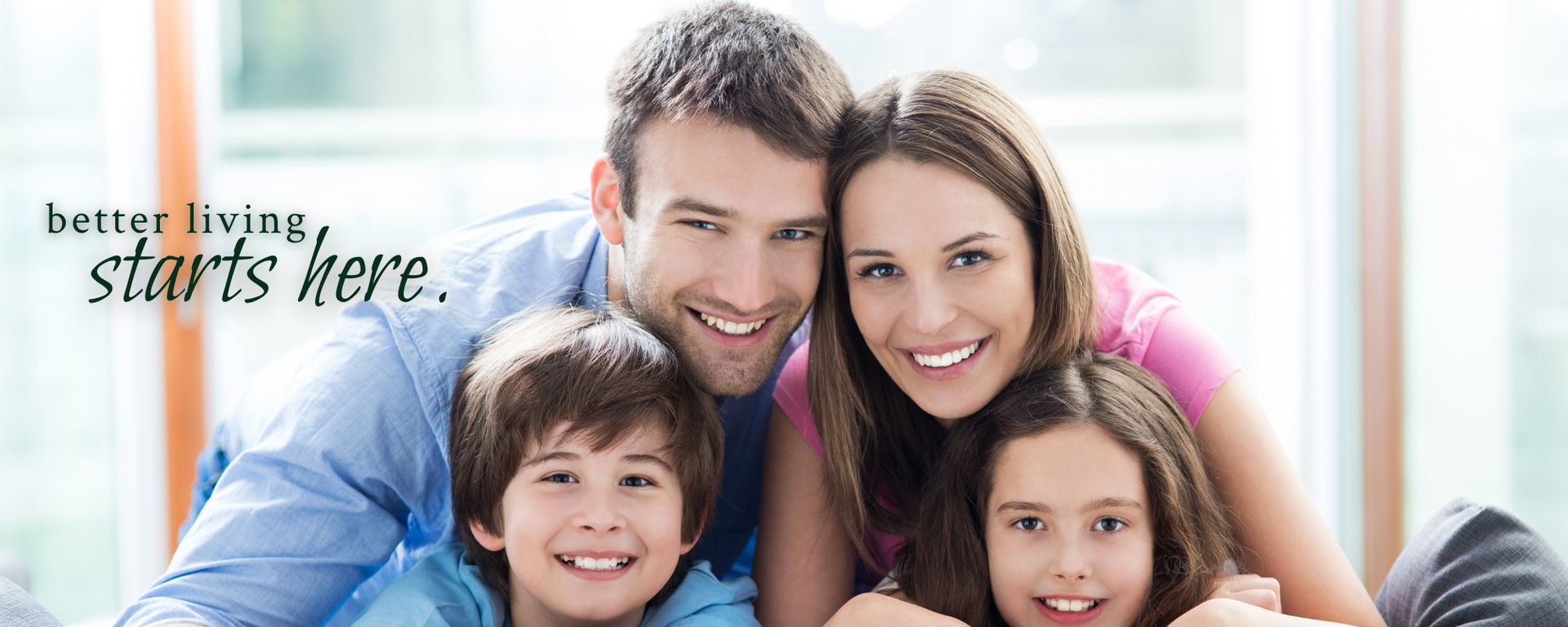 Smiling family on a couch with the text “better living starts here.”
