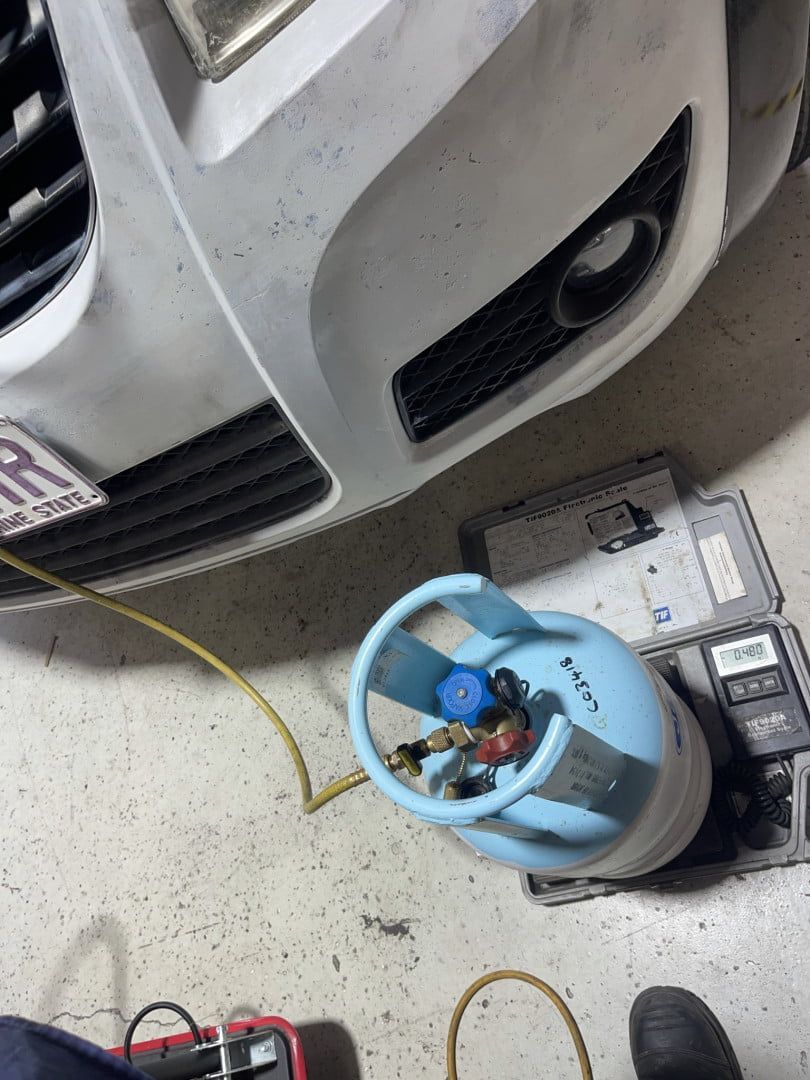 A Car is Being Worked on in a Garage With a Propane Tank Attached to It — Cool Cats Auto Air in Urangan, QLD