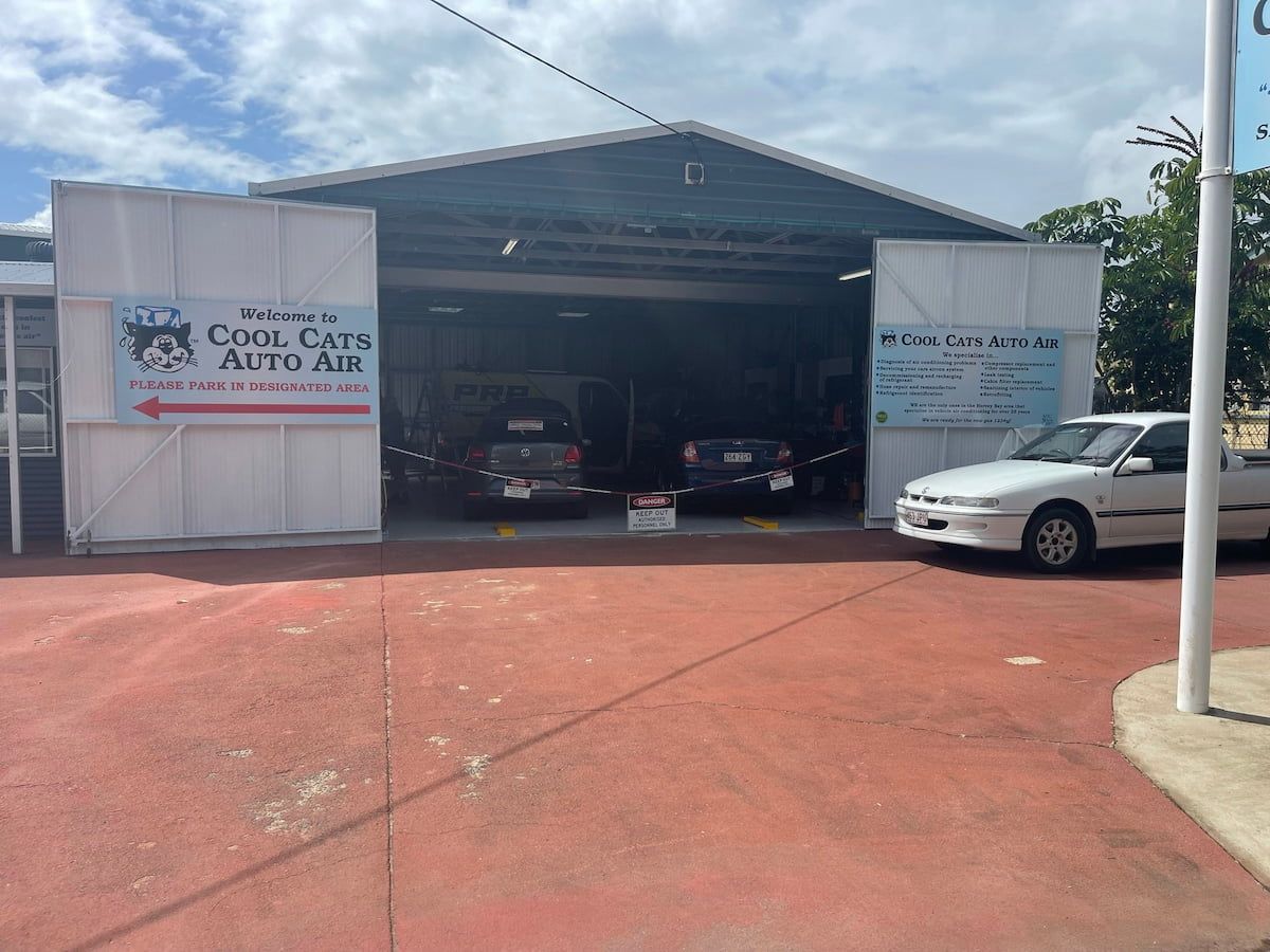 A White Car is Parked in Front of a Building That Says Cool Cats Auto Air — Cool Cats Auto Air in Urangan, QLD