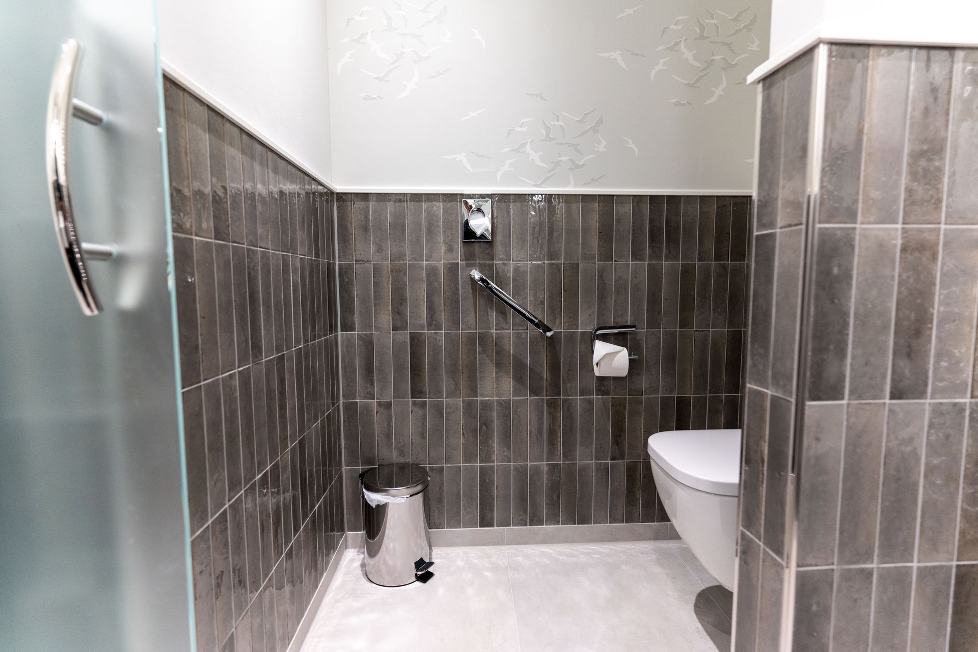 Ein Badezimmer mit Toilette und Mülleimer.