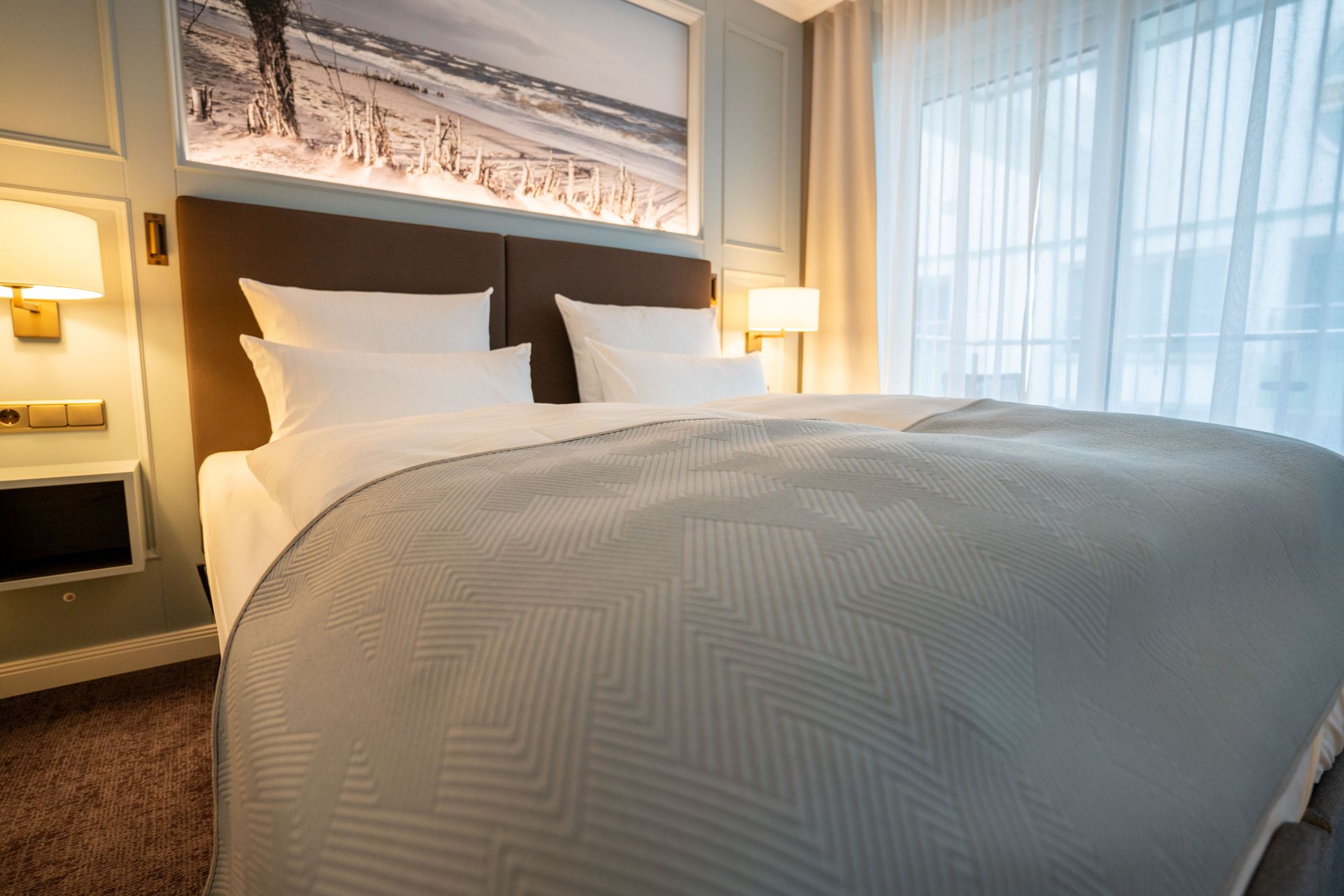 Ein Hotelzimmer mit einem großen Bett und einem Bild an der Wand über dem Bett.