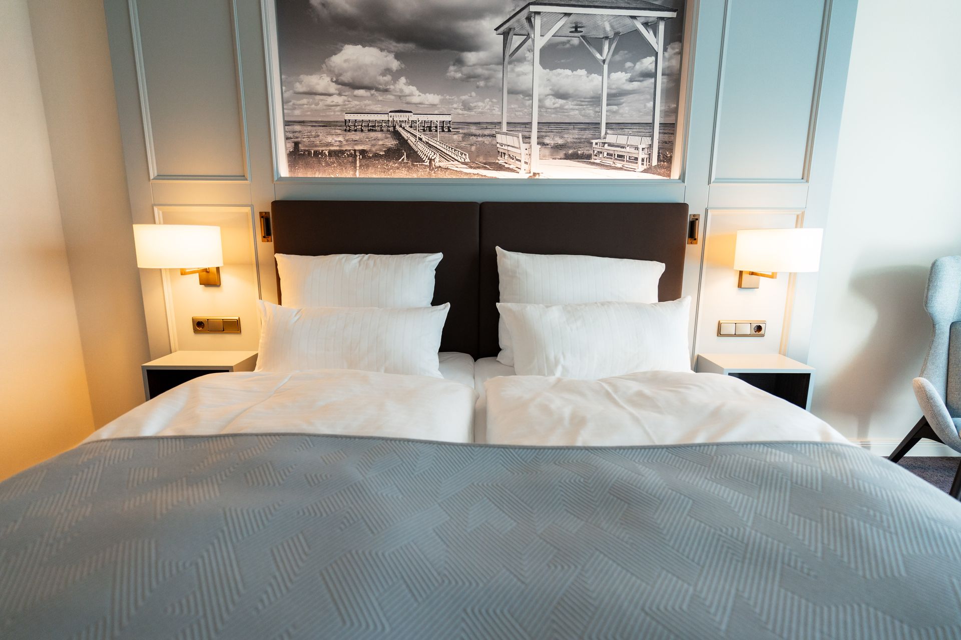 Ein Hotelzimmer mit einem großen Bett und einem Bild an der Wand darüber.