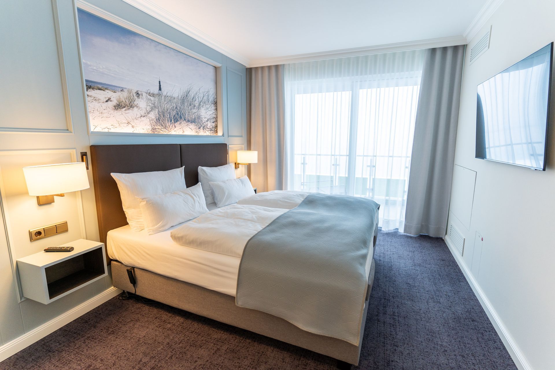 Ein Hotelzimmer mit zwei Betten und einem Flachbildfernseher.