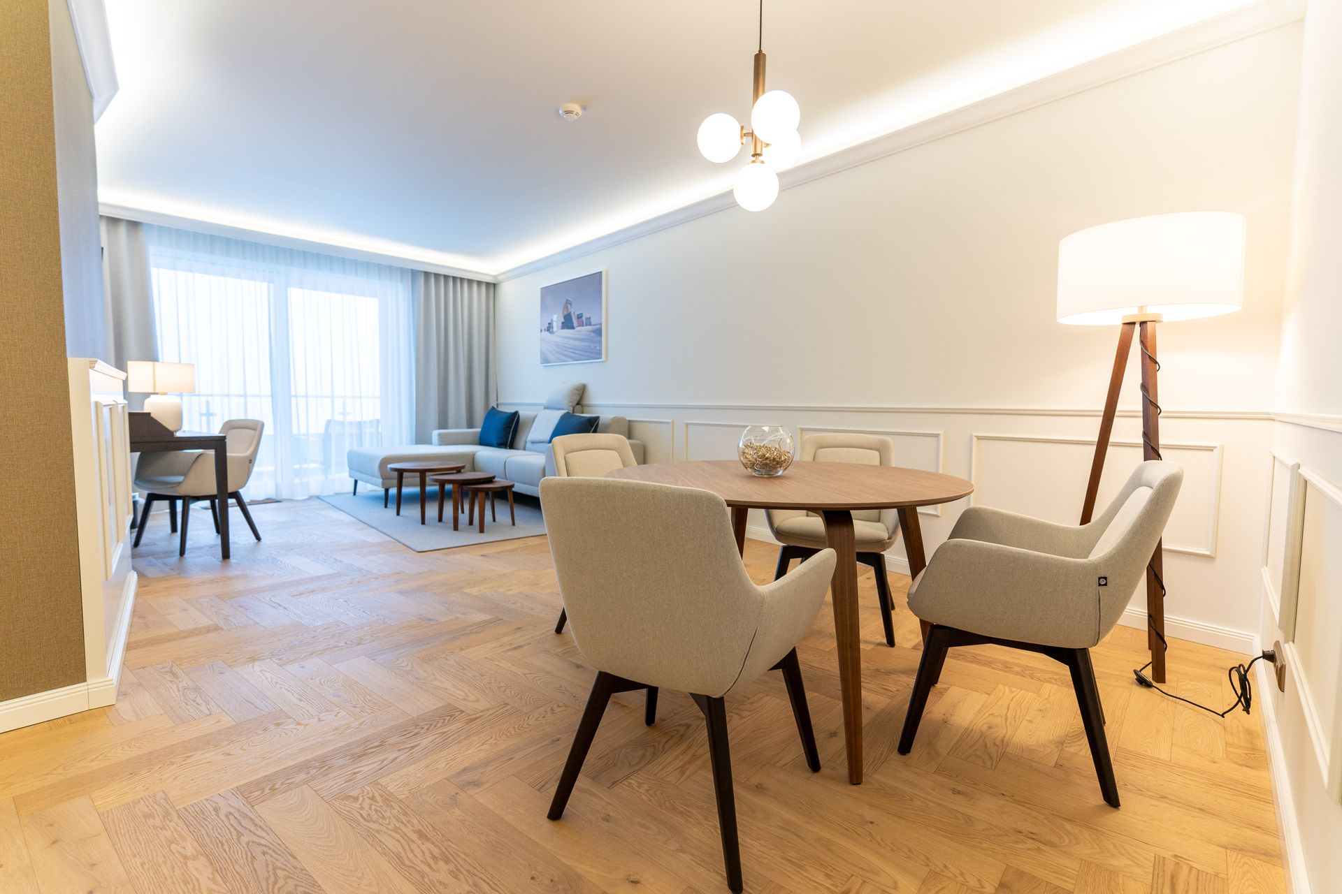 Ein Wohnzimmer mit einem Tisch, Stühlen und einer Lampe.
