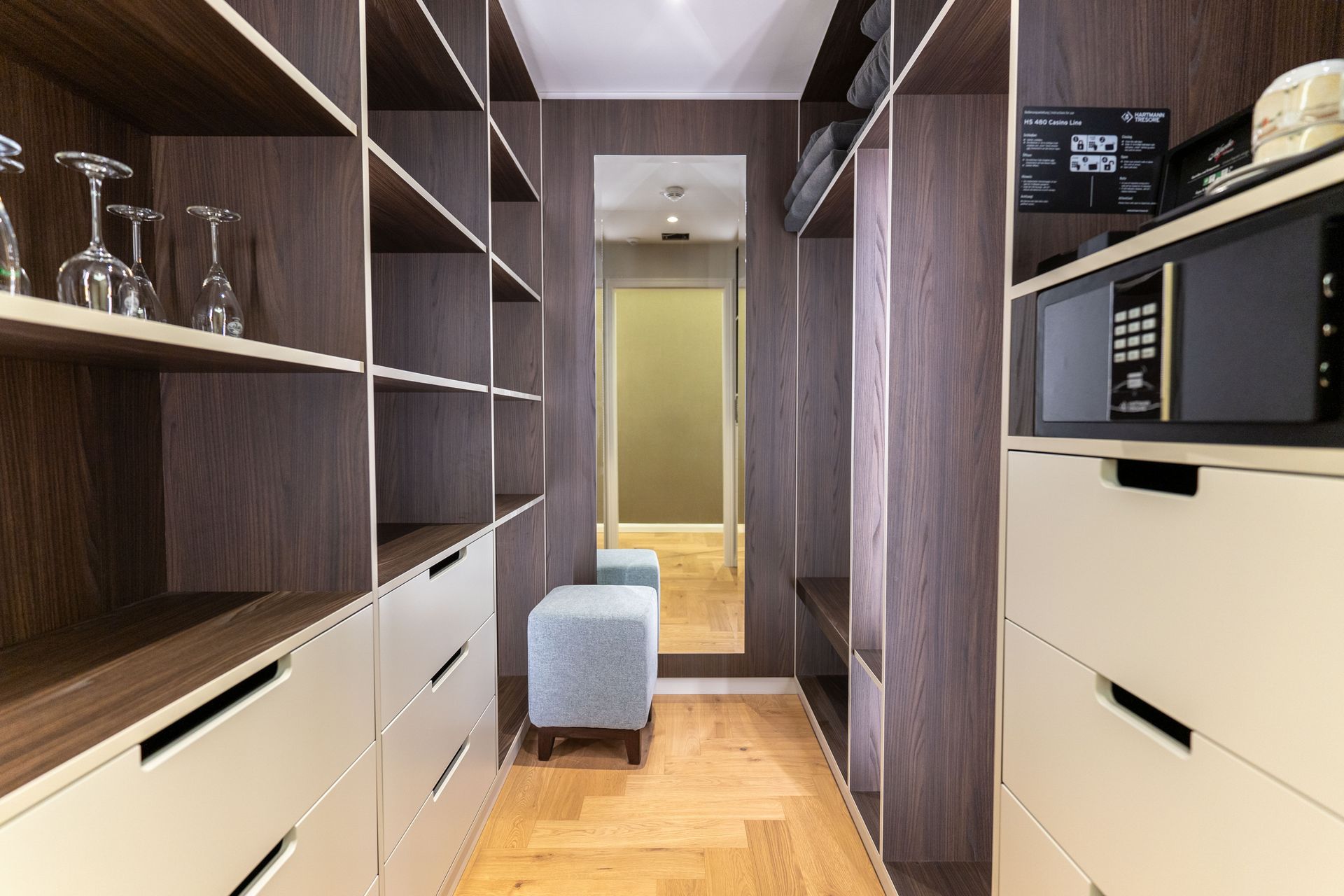 Ein begehbarer Kleiderschrank mit Mikrowelle und Spiegel
