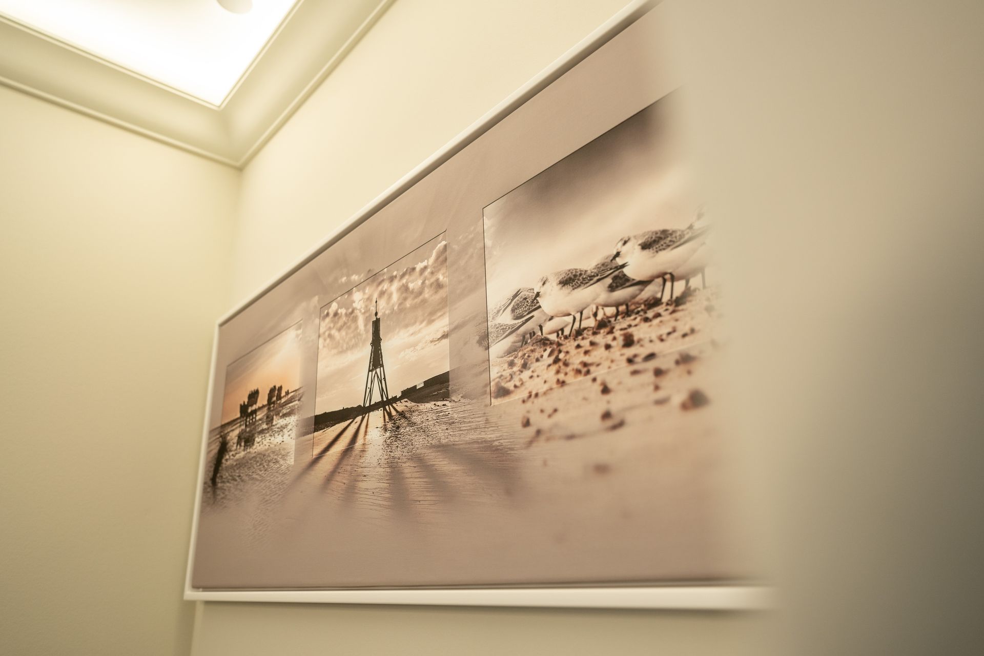 An einer Wand hängt ein Bild von einem Strand.
