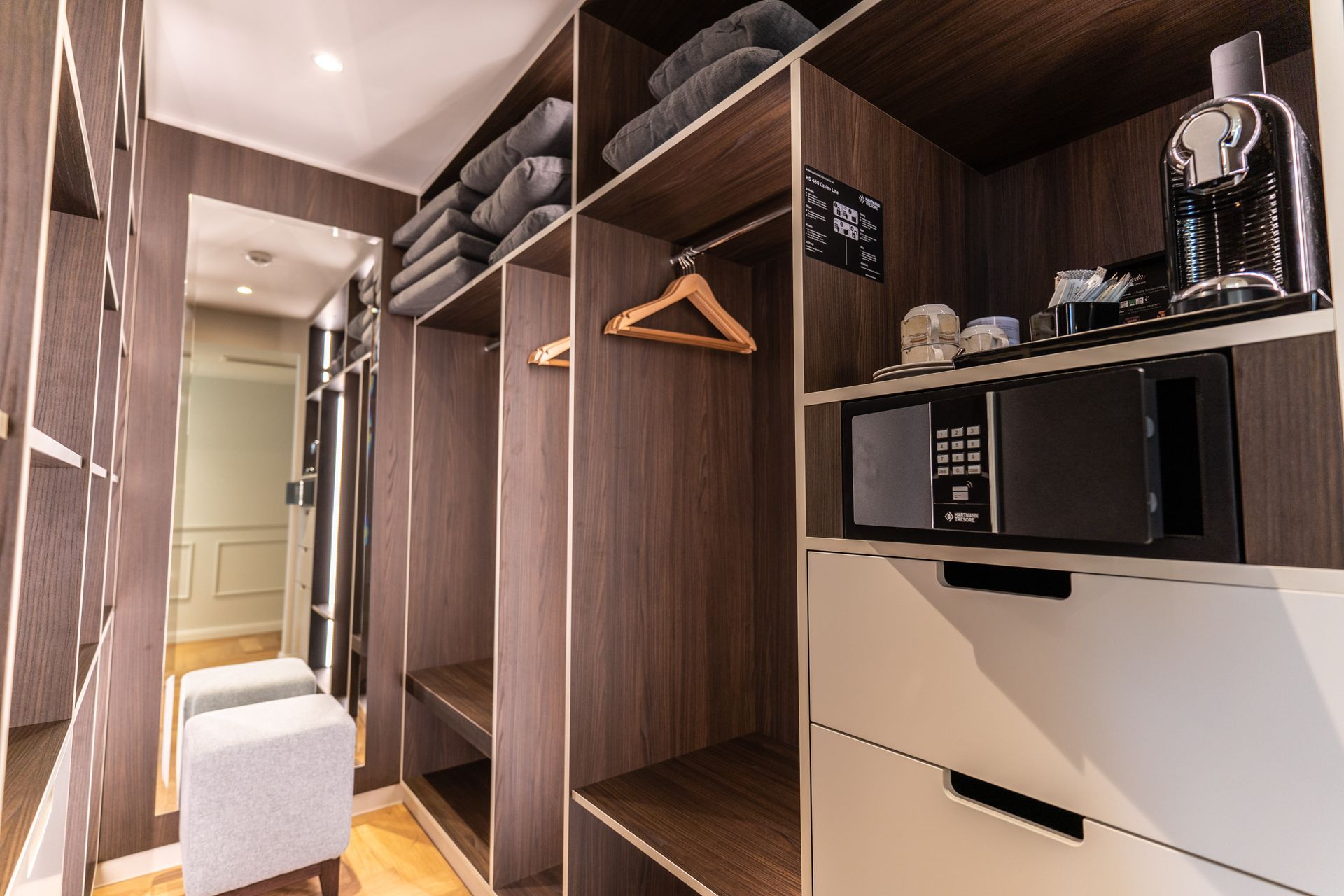 Ein begehbarer Kleiderschrank mit Mikrowelle und Safe.