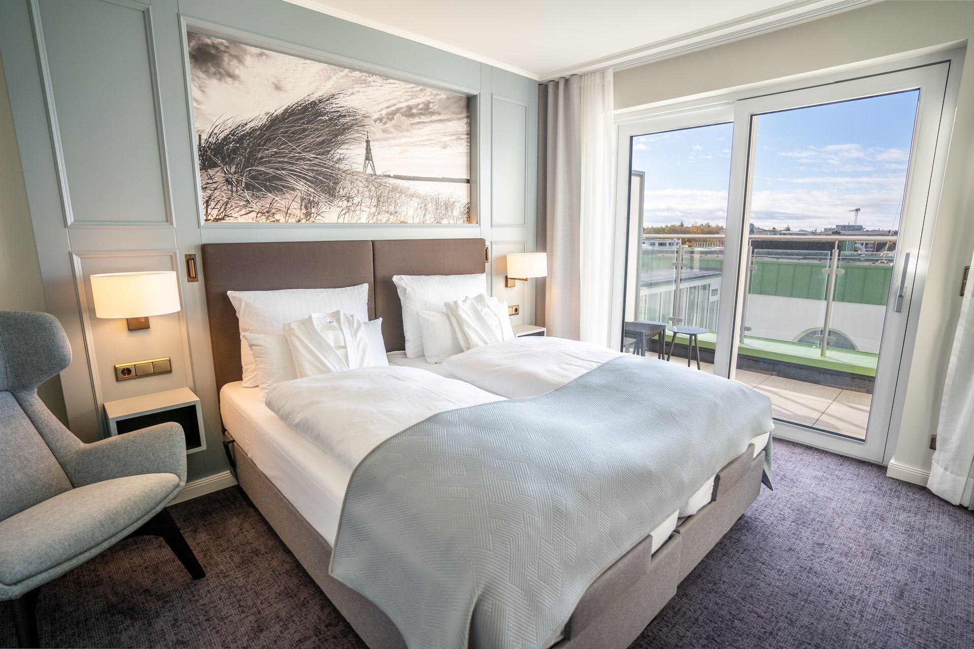 Ein Hotelzimmer mit zwei Betten, einem Stuhl und einem Balkon.